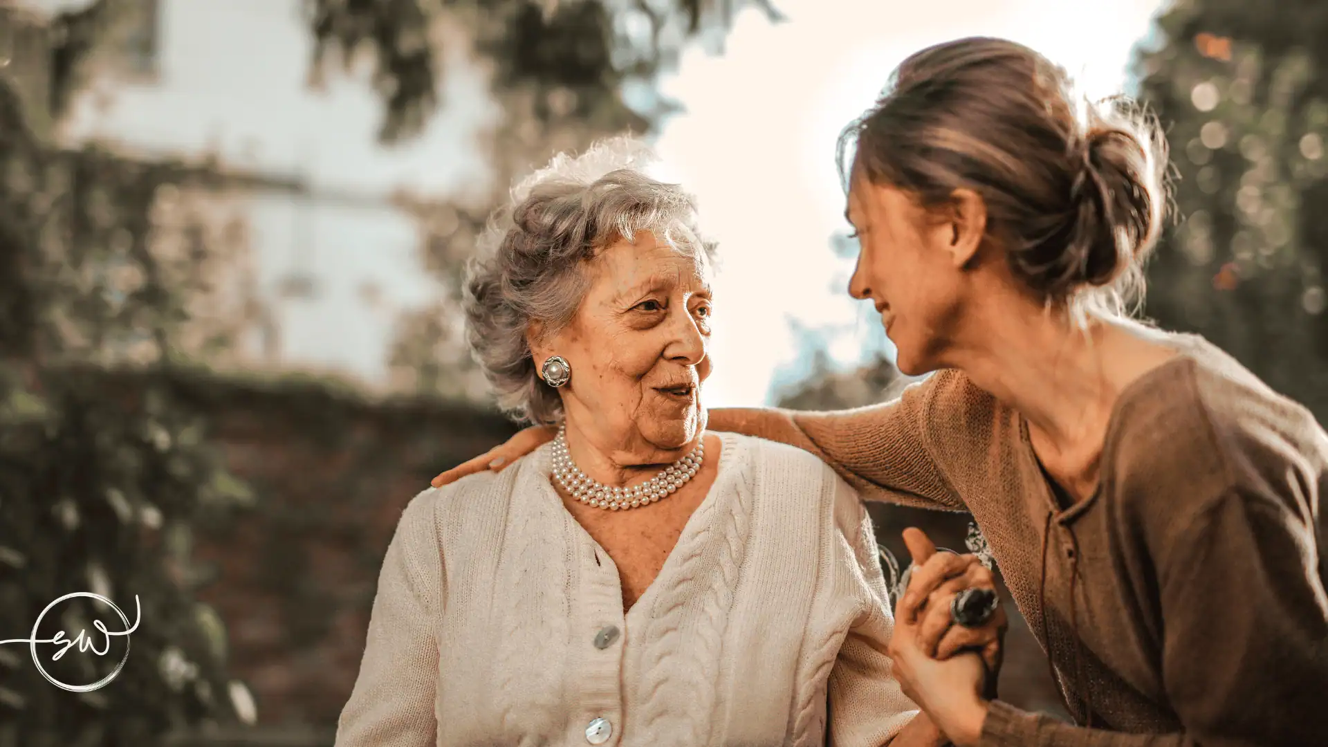 Grandmother and adult granddaughter sharing a warm, trusting moment outdoors